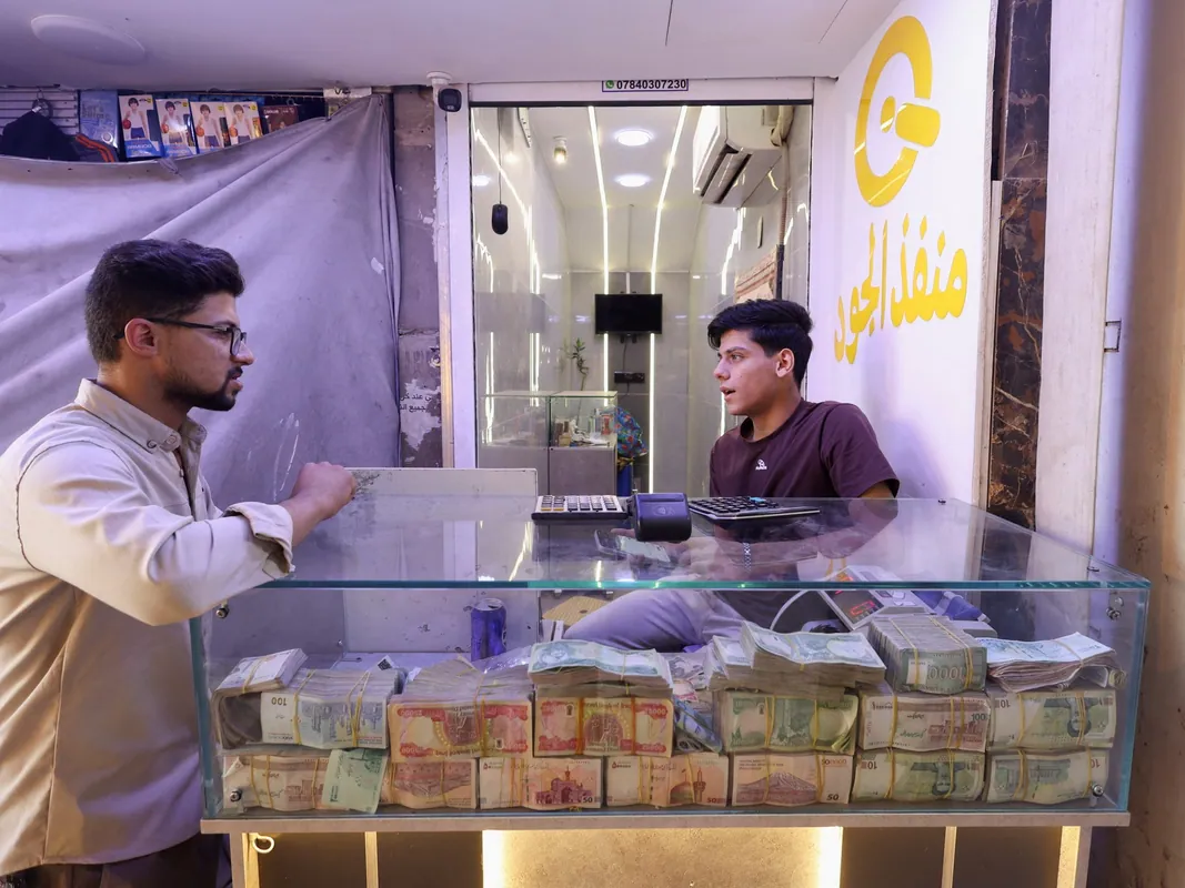 Iraq devalues dinar as oil revenue falls and lawmakers challenge move